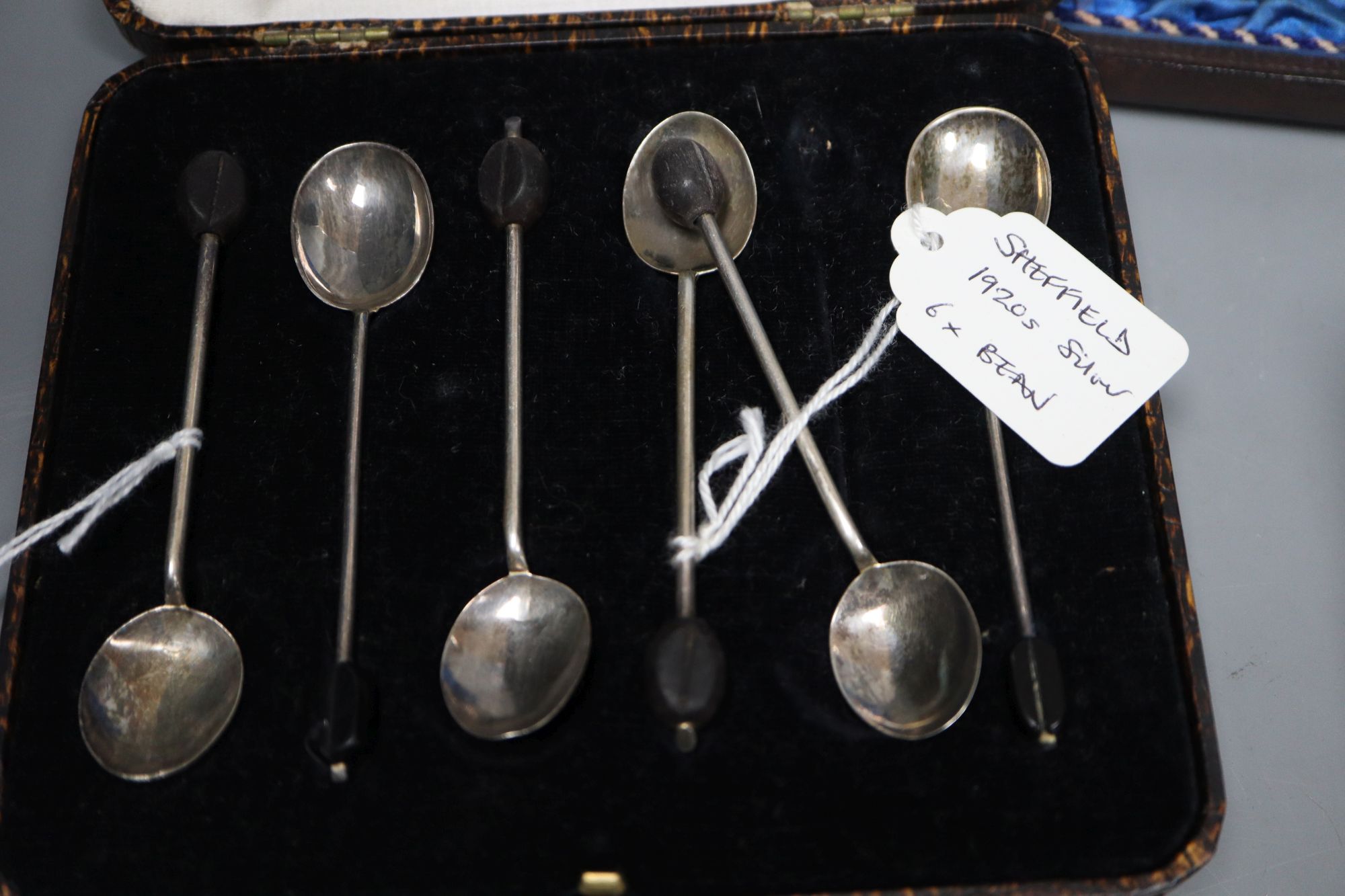 Twelve Victorian silver Apostle coffee spoons and sugar tongs, and three sets of six silver bean end coffee spoons, all cased